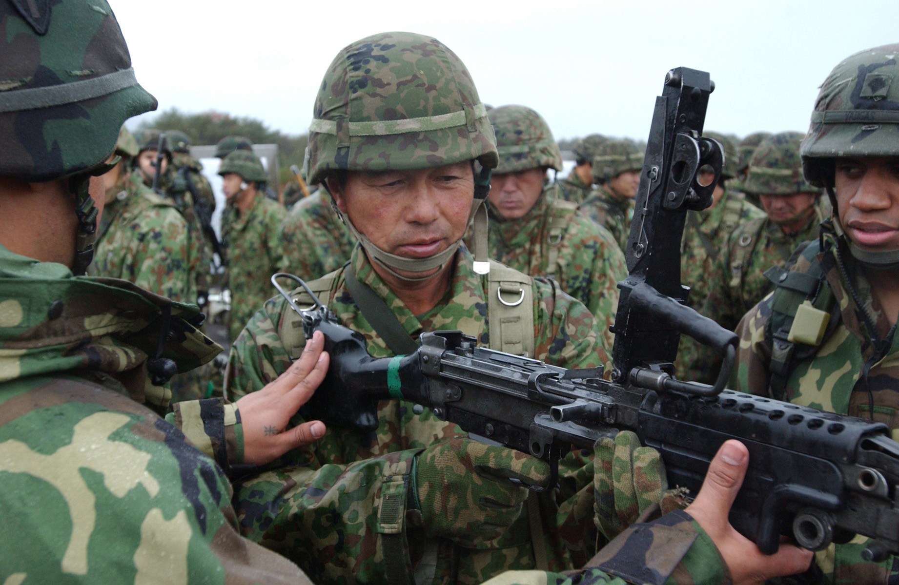 American soldiers demonstrate automatic weapon to Japanese soldier
